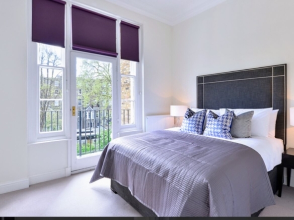 Second bedroom with double bed and purple blinds at Somerset Court